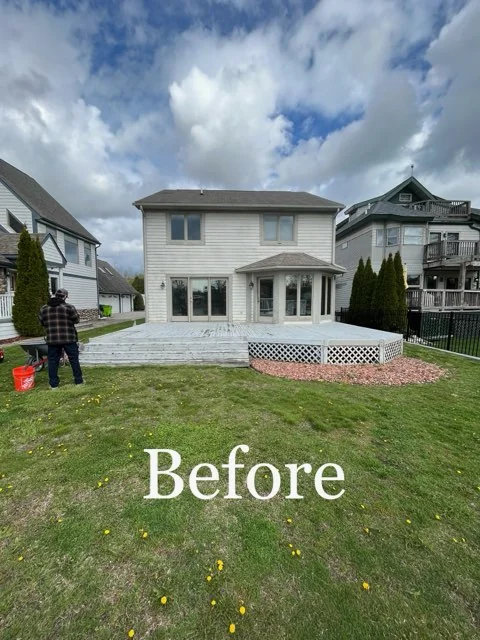 Plain colonial back exterior before remodel — white vinyl siding, basic concrete deck, and standard windows