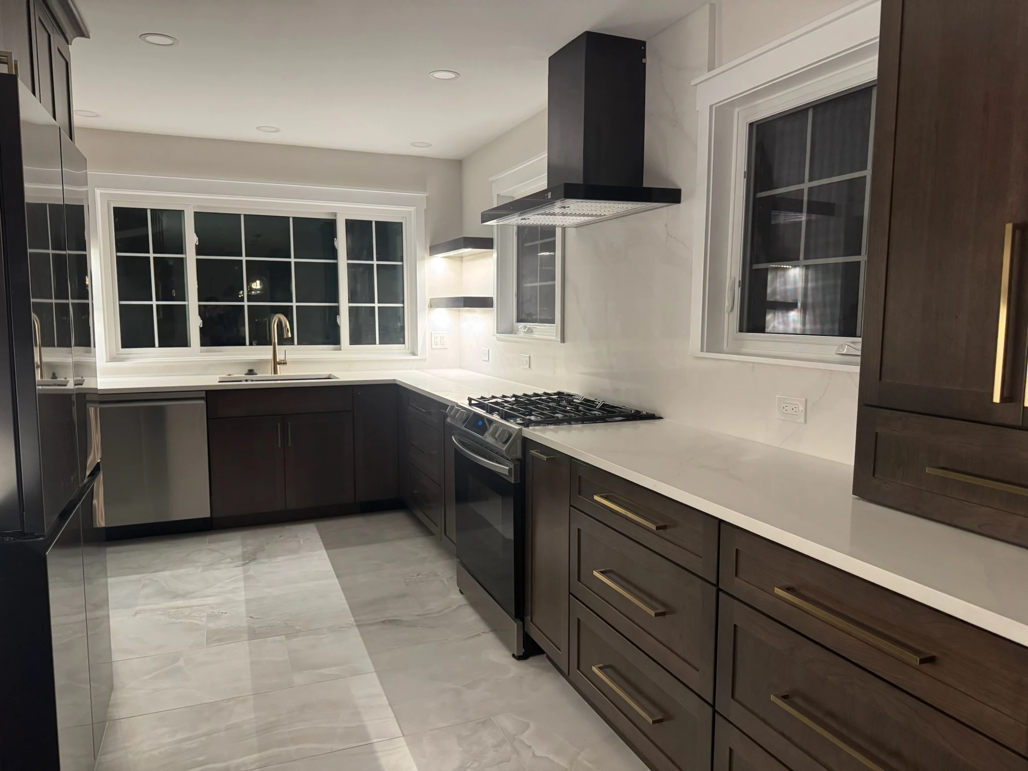 Dark walnut kitchen with quartz counters and brass hardware