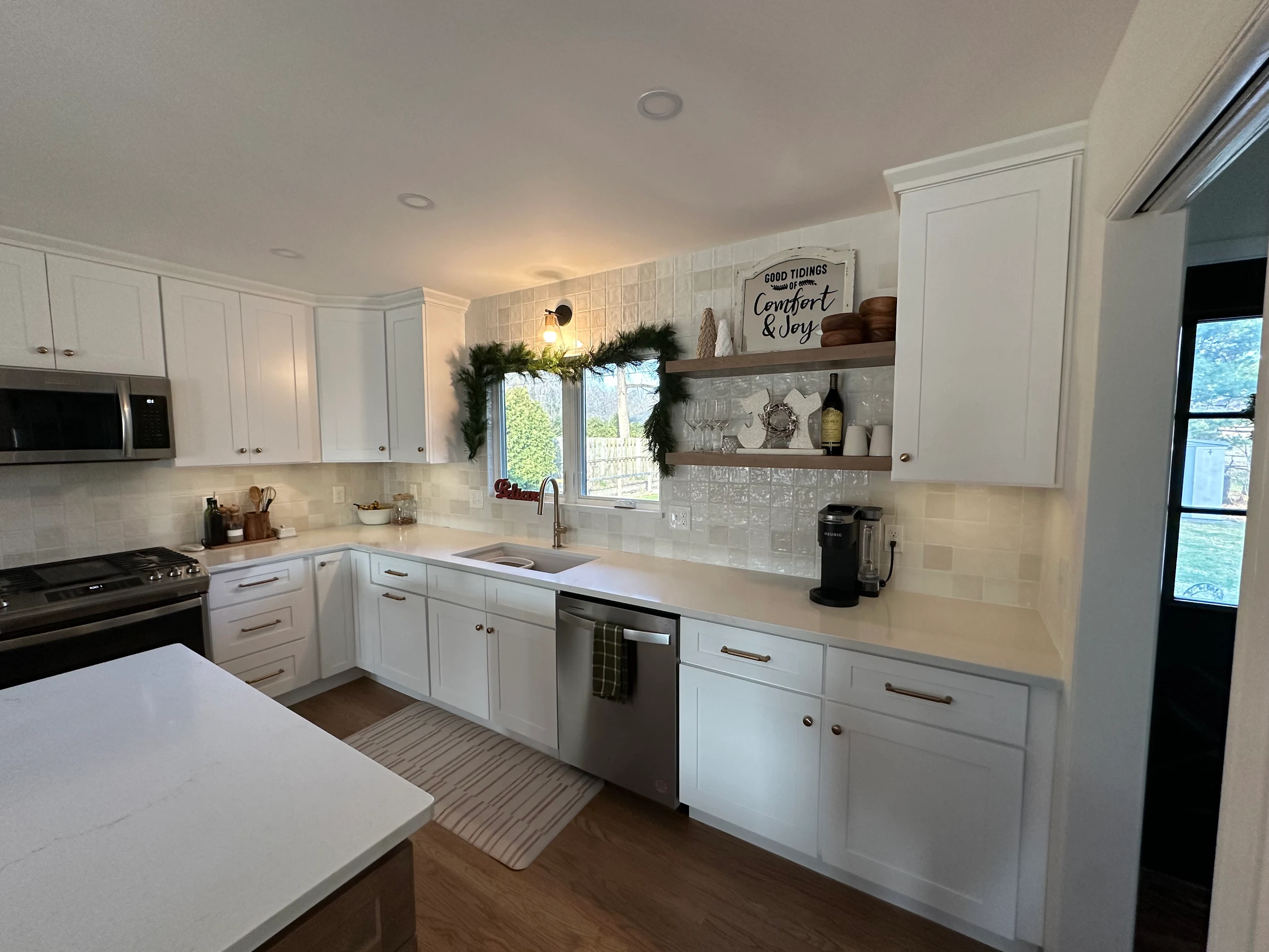 White kitchen with floating shelves and tile backsplash